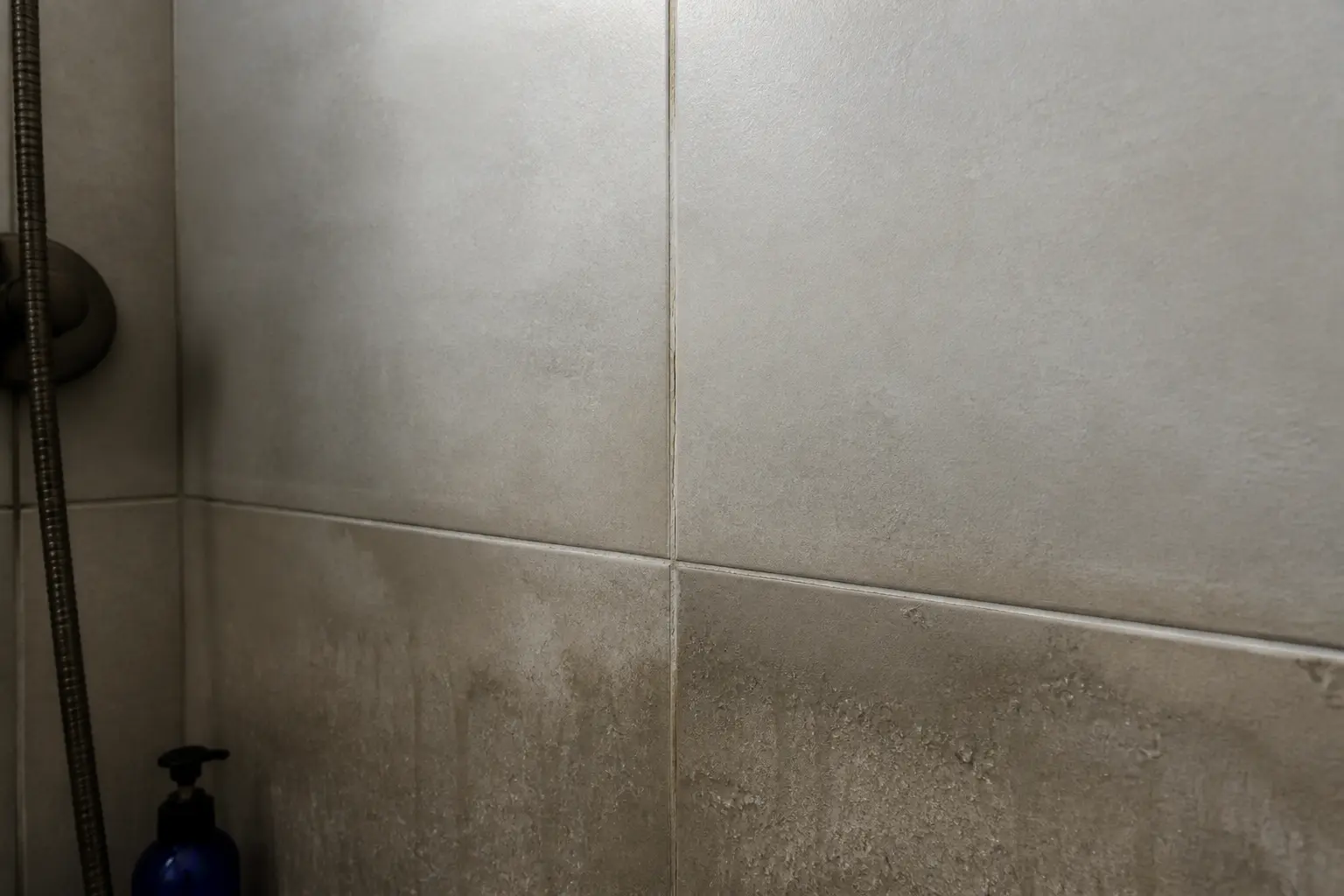 Peindre carrelage douche : coin de douche en carrelage mat avec joint fissuré et zone humide à inspecter avant peinture