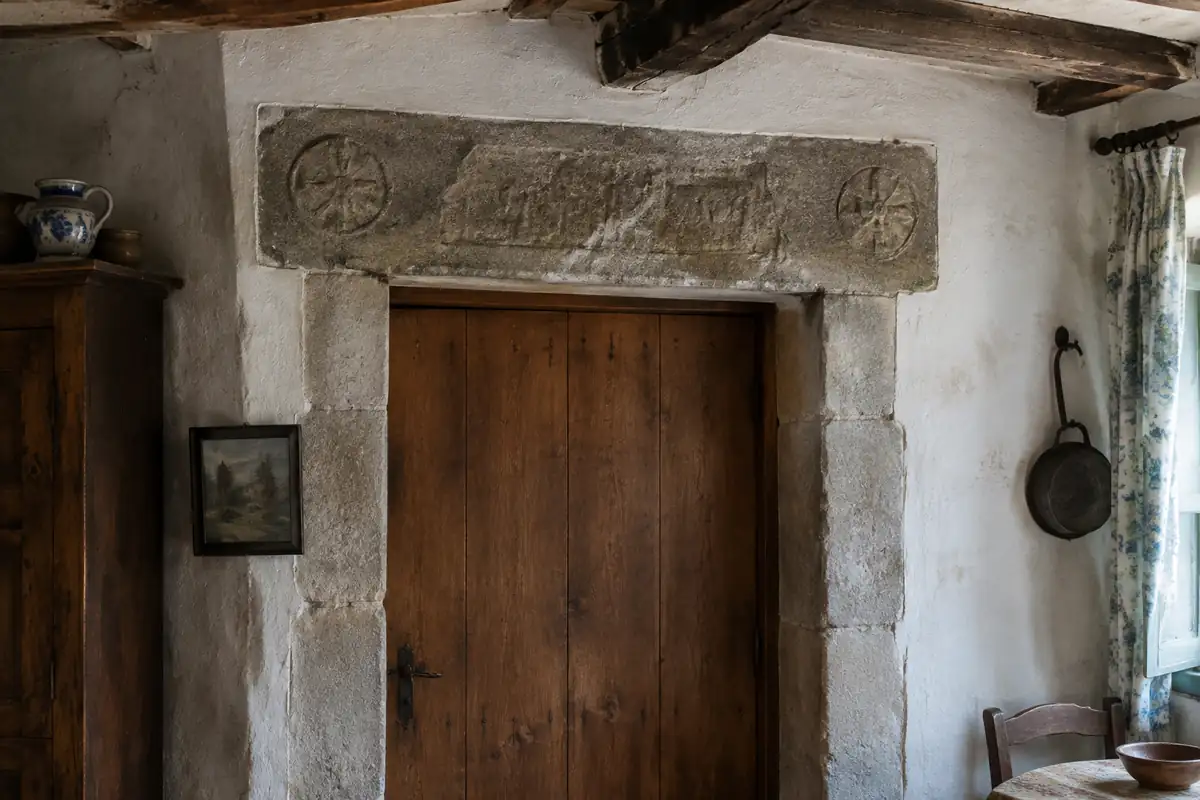Linteau de pierre gravé au-dessus d'une porte en bois d'une maison ancienne